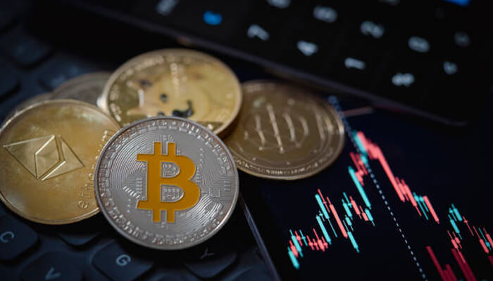 1 1 - Incryptocoin Bitcoin and Ethereum coins placed on a laptop keyboard with price charts showing cryptocurrency for investment performance.